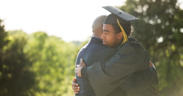 College graduate hugging his father