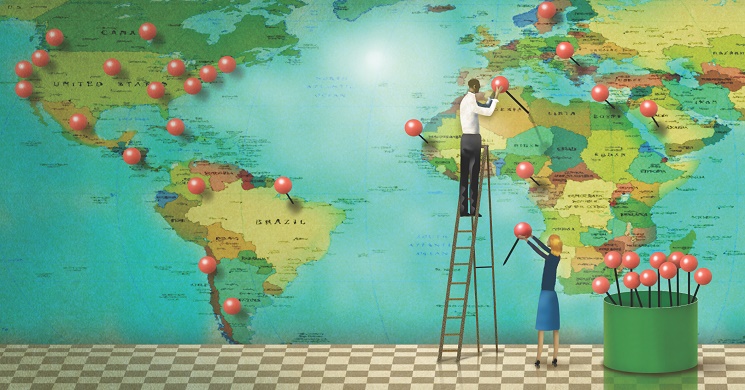 Two people marking a map with pins