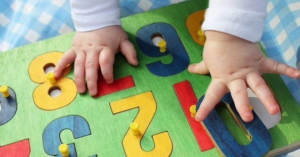 chubby baby hands reaching for puzzle