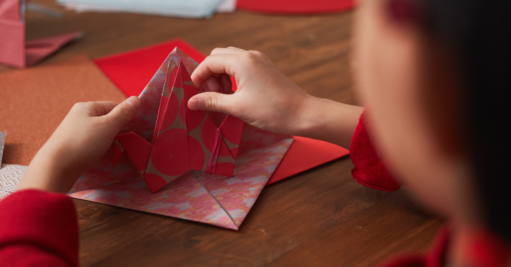person folding paper, origami